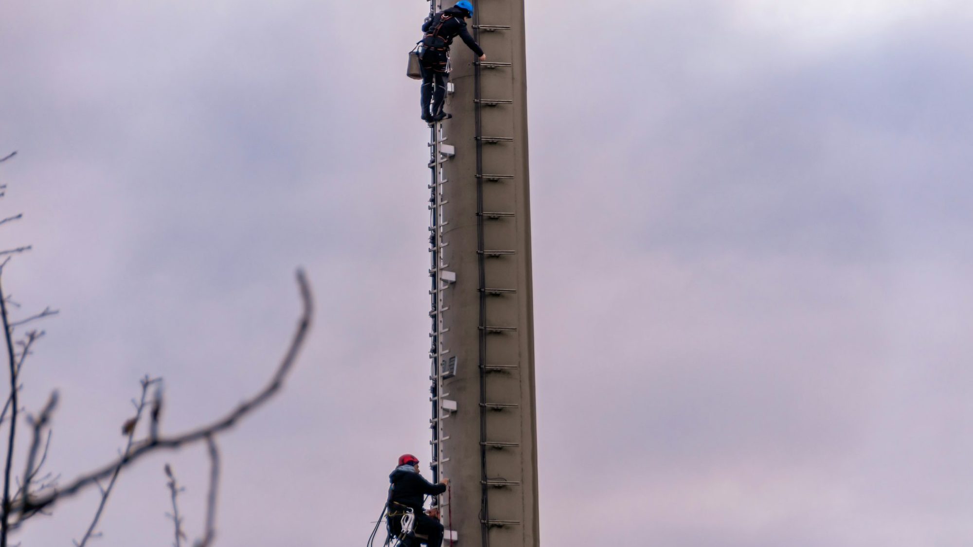 Tower crew working at height on a macro telecom tower during a wireless build.